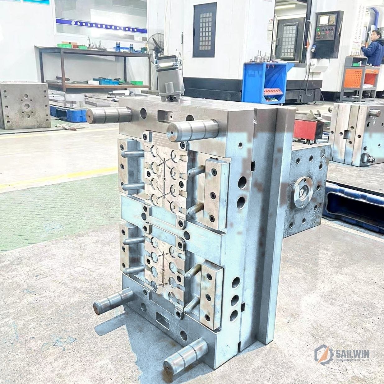 16-cavity edible oil cap mold plate on assembly stand in CNC machining workshop with blue floor Sailwin
