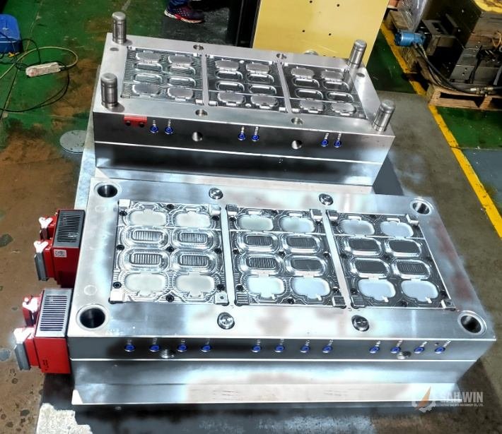 18-cavity oval flip-top cap mold with hot runner controller cables on workshop bench Sailwin
