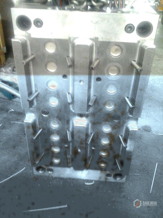 24-cavity cap mold core plate hoisted by crane in assembly hall with distressed blue floor Sailwin
