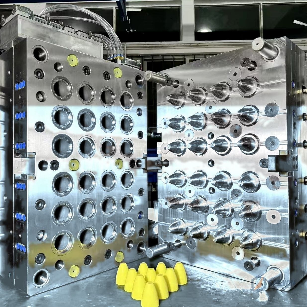 24-cavity condiment sauce squeeze cap injection mold with yellow cone dispensing caps on blue floor Sailwin