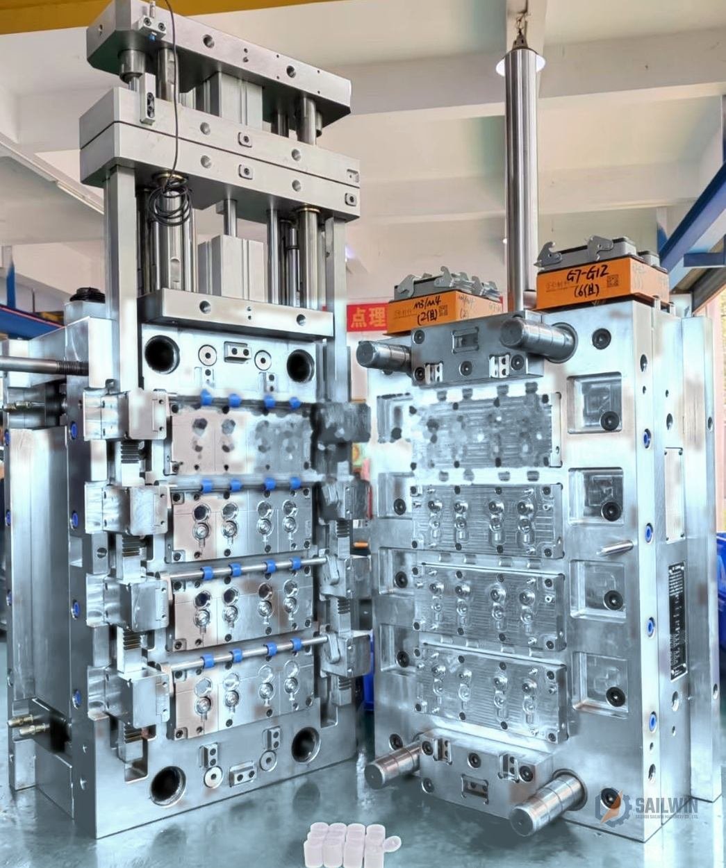 Heavy-duty multi-cavity flip-top sauce cap mold in assembly plant with blue floor Sailwin