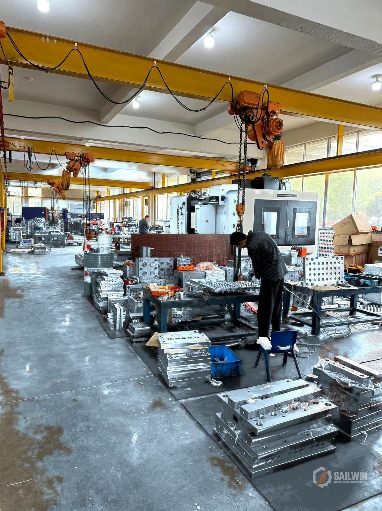 Sailwin heavy mold assembly plant with distressed light-blue epoxy floor and overhead cranes Sailwin