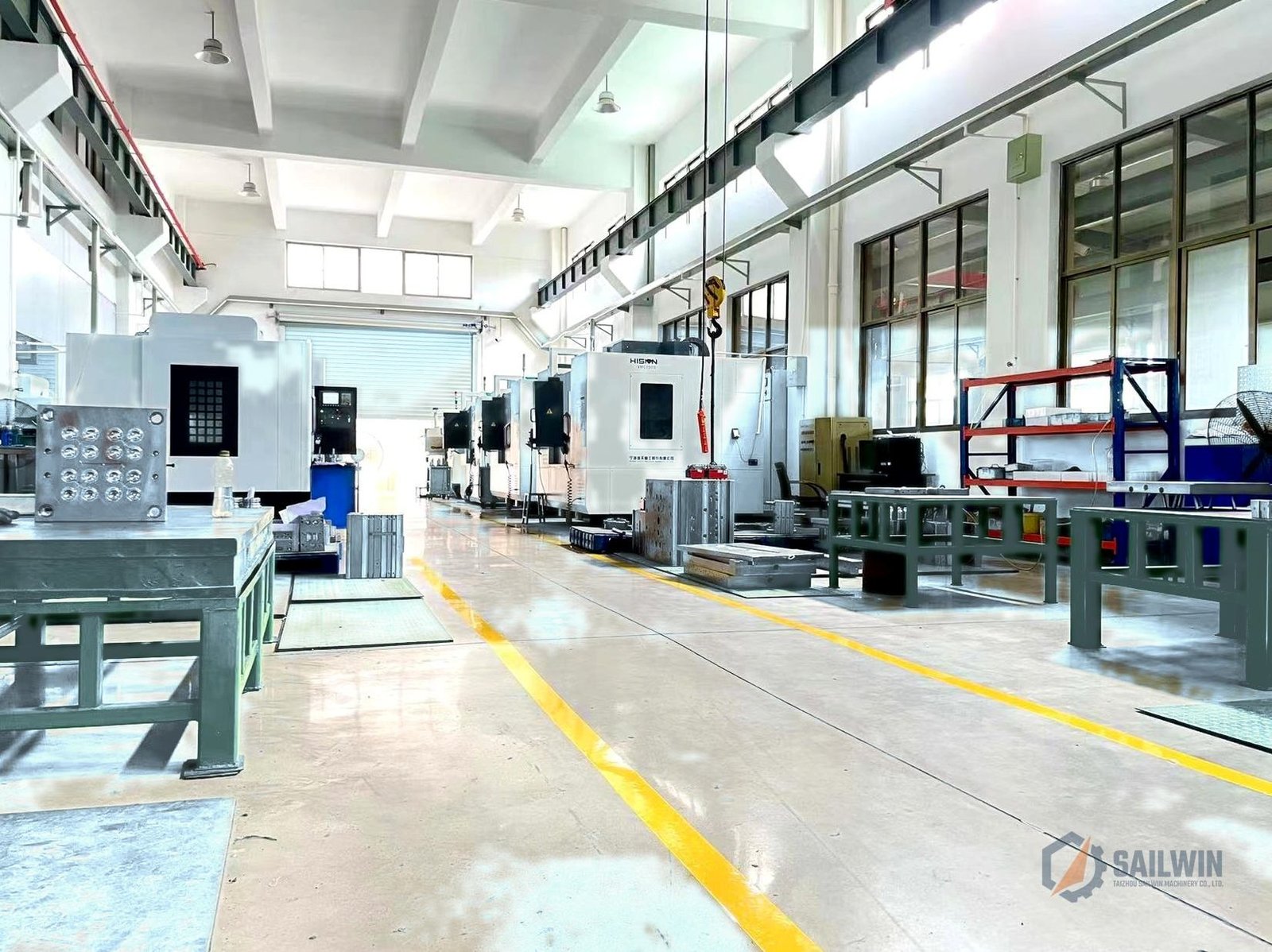Sailwin multi-axis CNC machining center line with mold plates and distressed blue floor Sailwin
