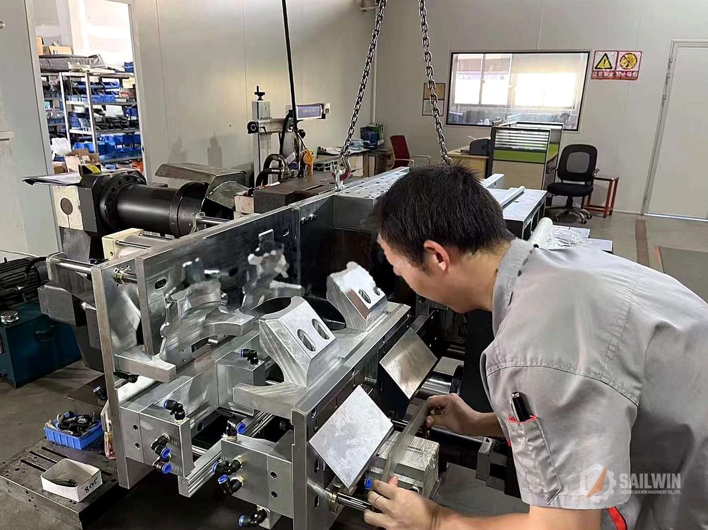 Sailwin technician adjusting automatic extrusion blow molding machine