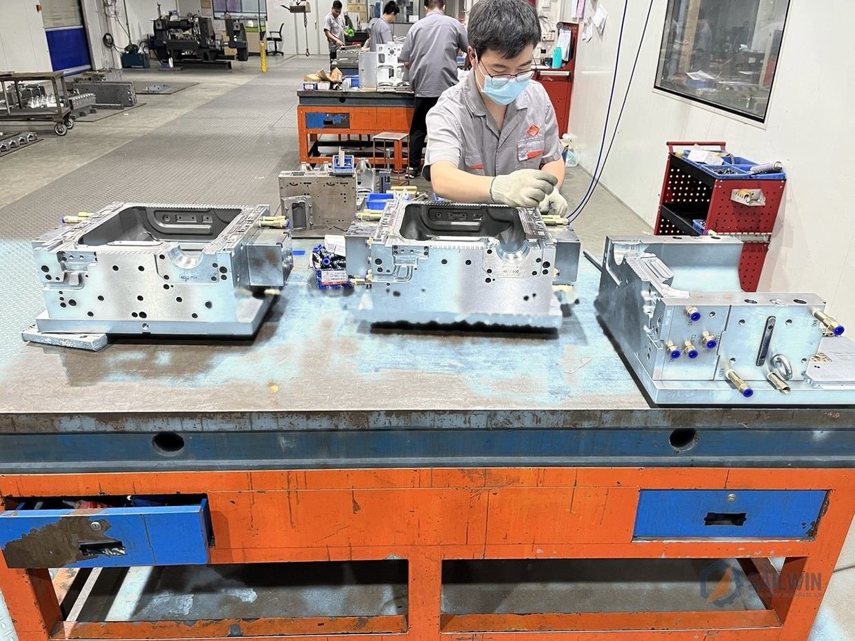 Sailwin tooling specialist assembling extrusion blow molds on workbench